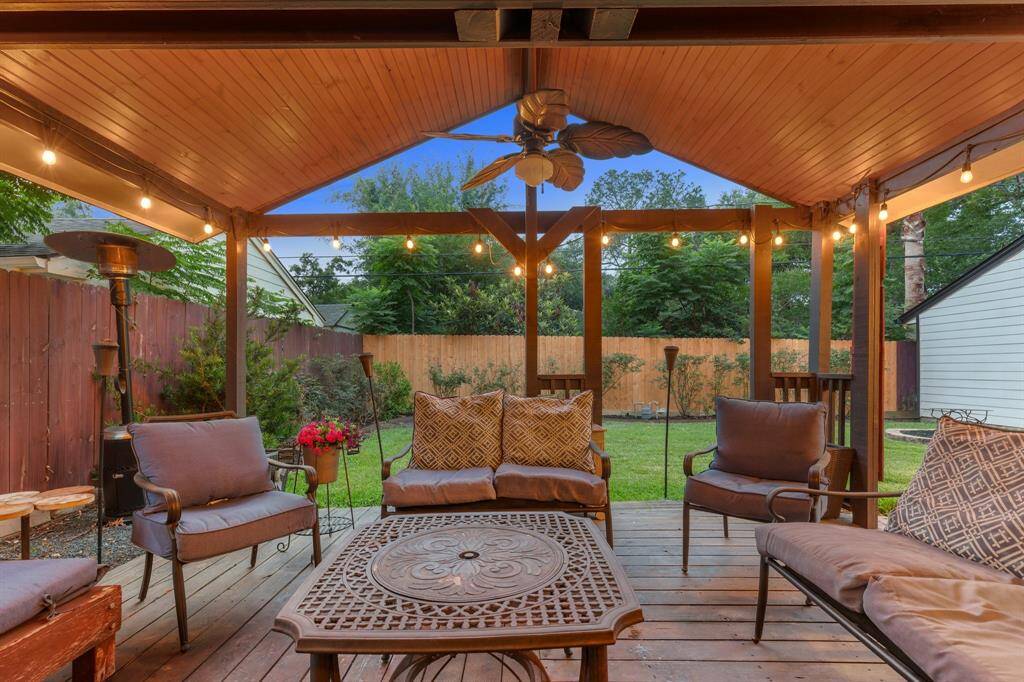 The extended back patio features a wood-paneled tongue-and-groove ceiling and a ceiling fan for year-round comfort. Surrounded by a fully fenced yard and mature landscaping, it’s an ideal space for casual gatherings or quiet evenings outdoors.