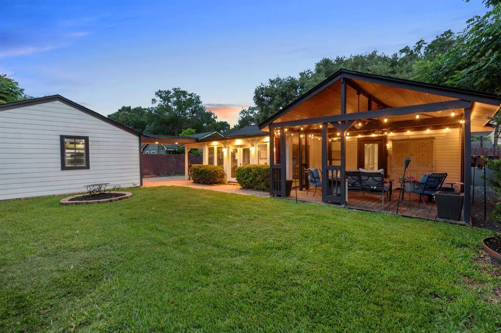 The extended covered patio adds a generous entertaining area just off the sunroom, with enough space for lounging, dining, or simply unwinding under the fans.