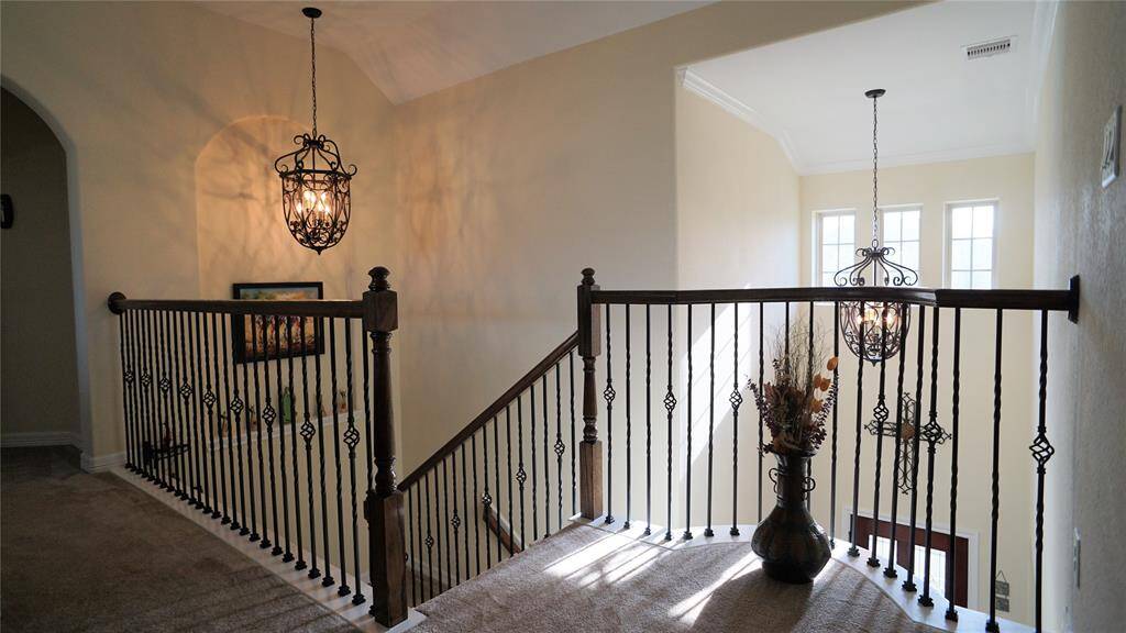 Beautiful wrought iron balusters and matching lanterns over foyer and top of stairs.