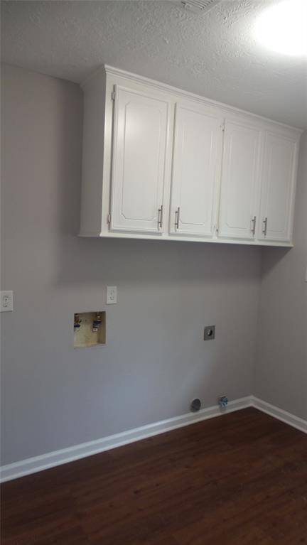 This large laundry area has plenty of room for an addition fridge or freezer.  Plenty of cabinet space to keep all the cleaning products tucked away.