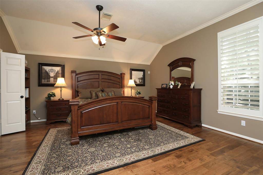 Master bedroom has a wall of windows and wood floors too.