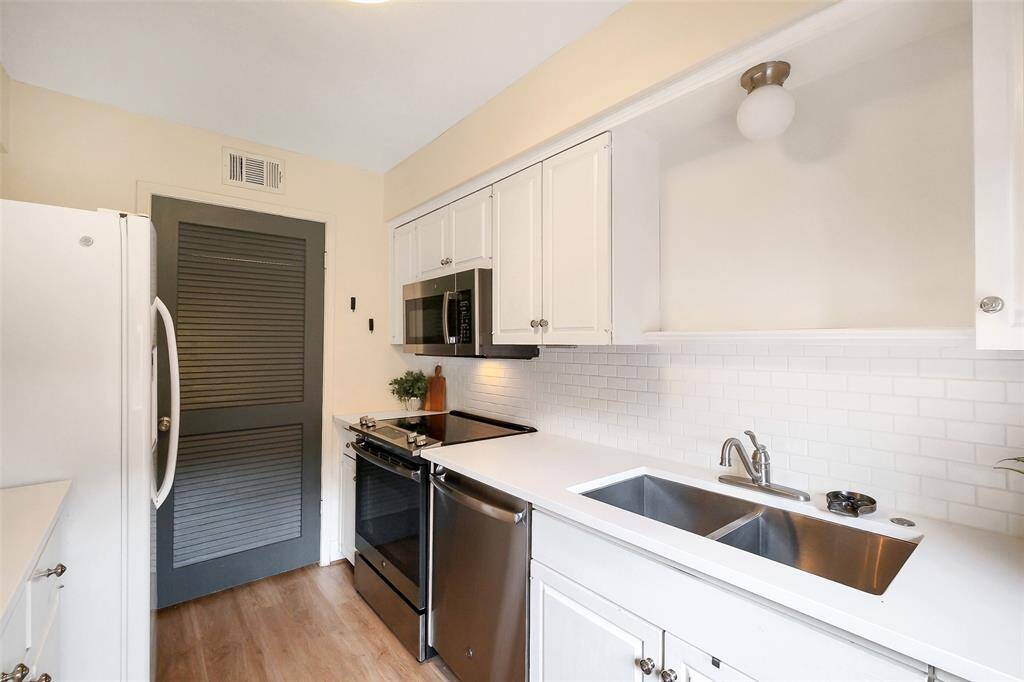 Kitchen has Quartz countertops, tile subway backsplash, and stainless steel applicances.