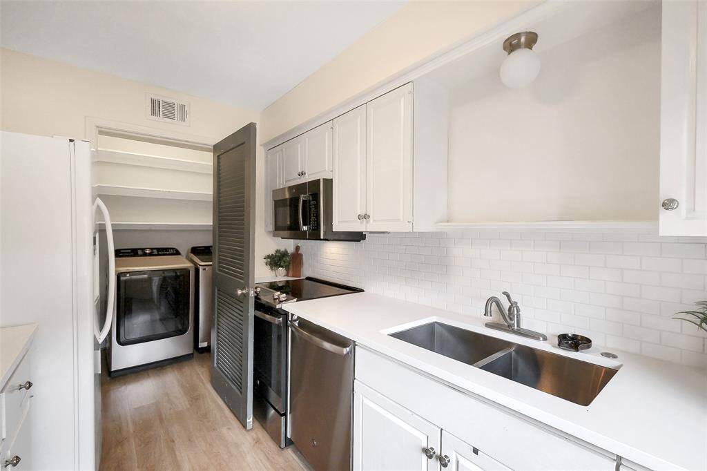 At the end of this cute kitchen find a spacious pantry with the washer and dryer.
