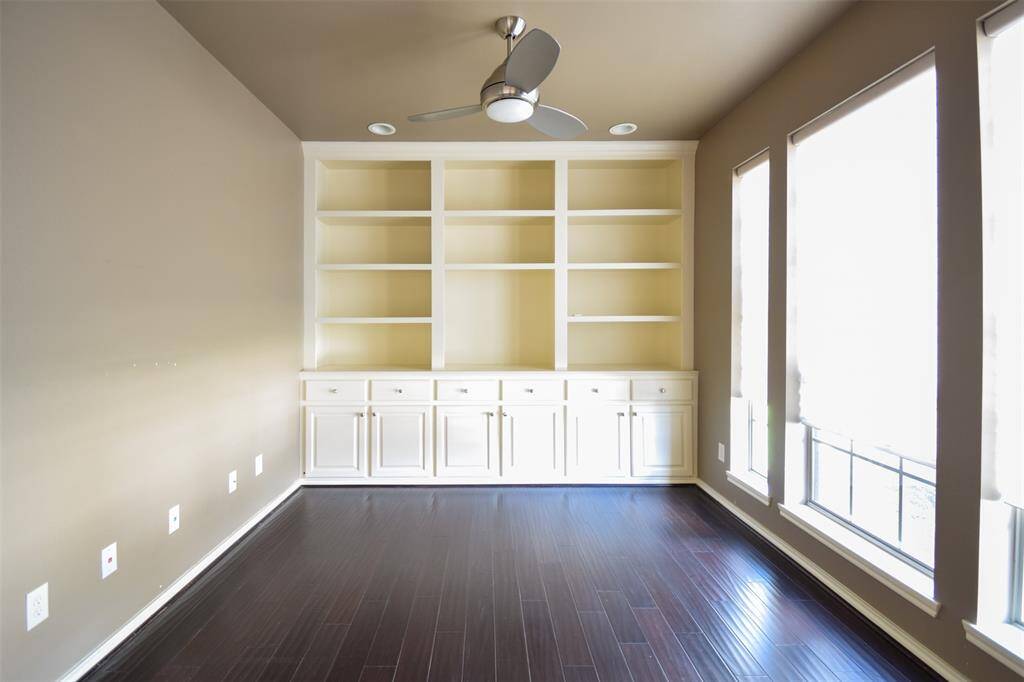 Home office with custom built in bookshelves and hand scraped wood flooring