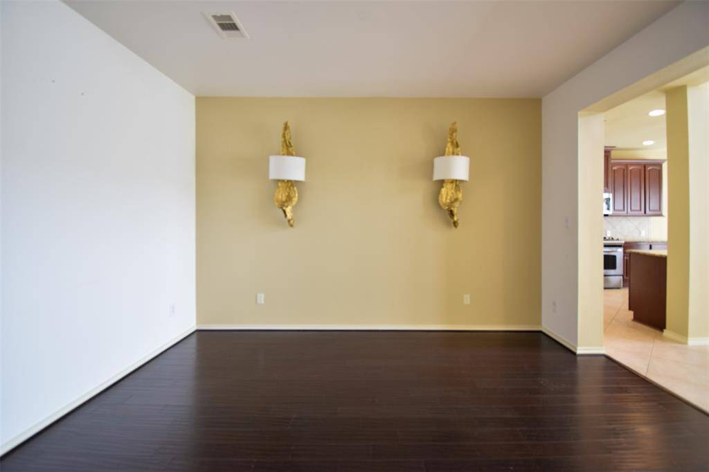 Formal dining room with customized wall sconces and hand scraped wood floor