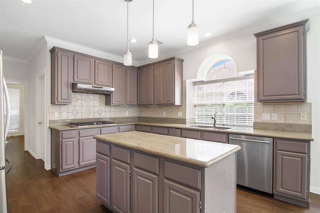 The kitchen with island and stainless steel appliances. THE KITCHEN CABINETS HAVE BEEN REPAINTED SEE LATER PHOTOS.