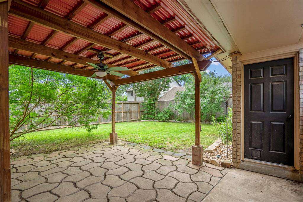 Now let’s head out back and check out the stunning backyard! The covered pergola is perfect for lounging with a cocktail in hand, relaxing under the fan while you take in views of your large, lush yard—pure backyard bliss.