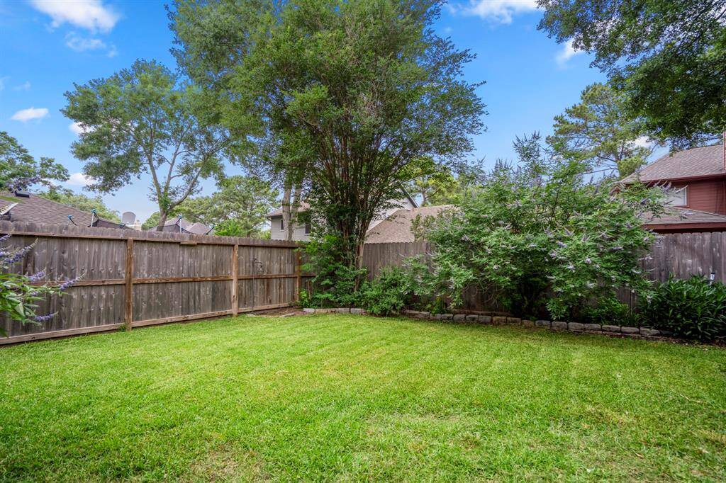 Now let’s head out back and check out the stunning backyard! The covered pergola is perfect for lounging with a cocktail in hand, relaxing under the fan while you take in views of your large, lush yard—pure backyard bliss.