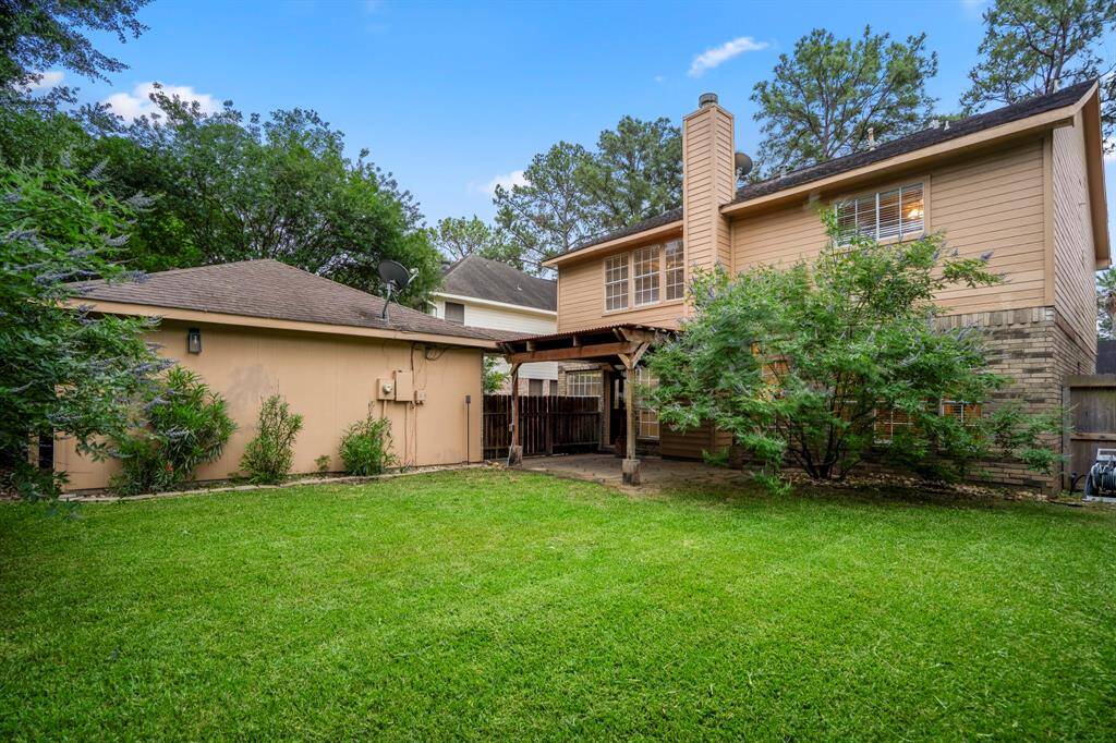 Now let’s head out back and check out the stunning backyard! The covered pergola is perfect for lounging with a cocktail in hand, relaxing under the fan while you take in views of your large, lush yard—pure backyard bliss.