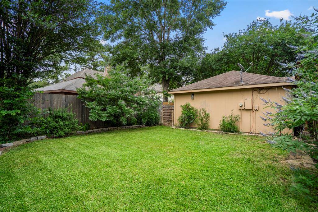 Now let’s head out back and check out the stunning backyard! The covered pergola is perfect for lounging with a cocktail in hand, relaxing under the fan while you take in views of your large, lush yard—pure backyard bliss.
