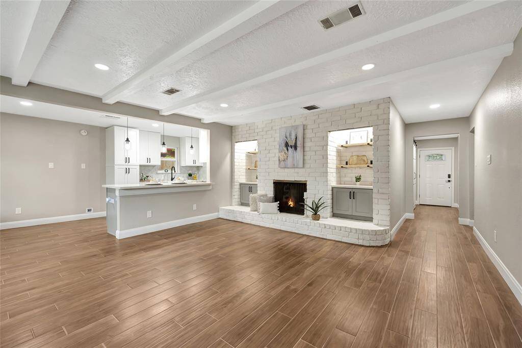 View of living room, front door and kitchen