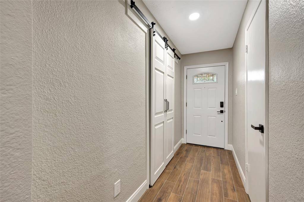 view of front door straight ahead, Laundry room to the left behind barn doors and closet for storage on your right.