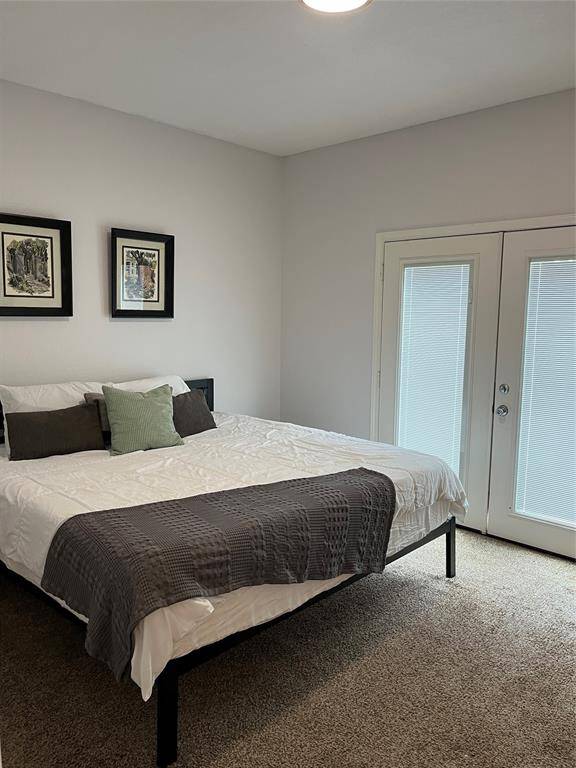 Primary bedroom with door to backyard and patio.