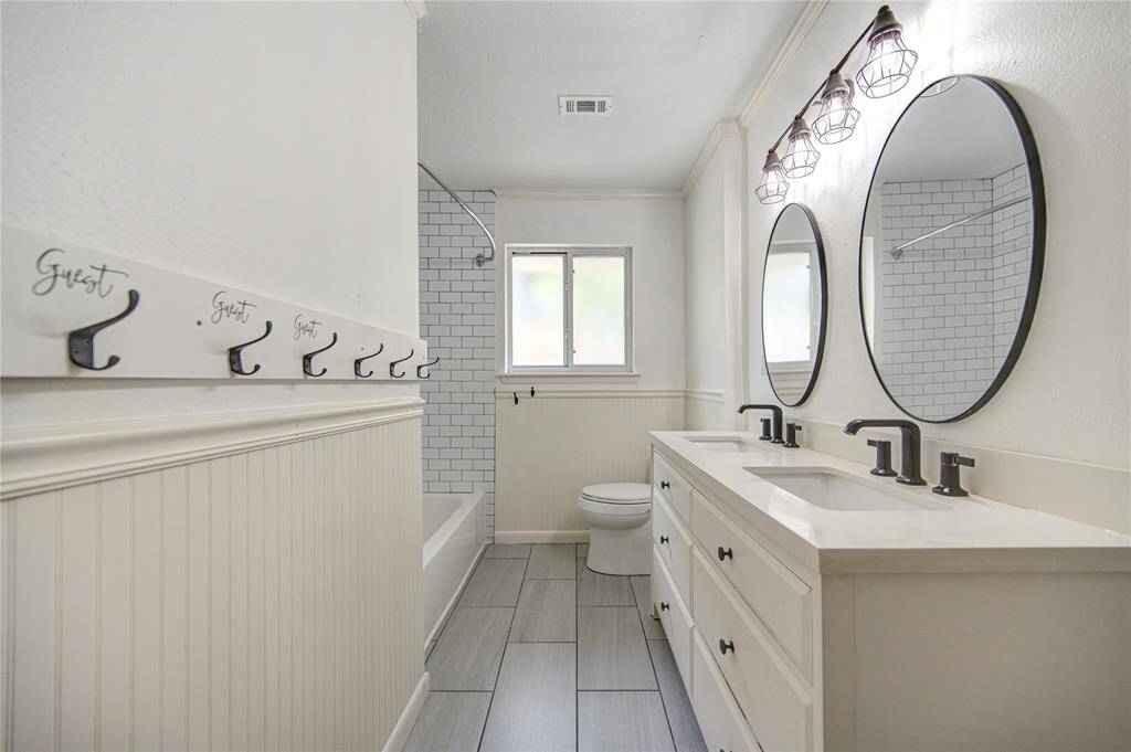 Secondary bath w/ dual sinks and shower / tub combo w/ subway tile