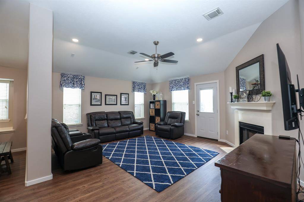 The open living room is accented by a beautiful fireplace and high ceiling.