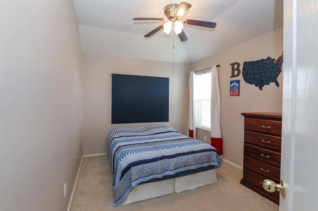 2nd of 3 secondary bedrooms with a ceiling fan and neutral paint