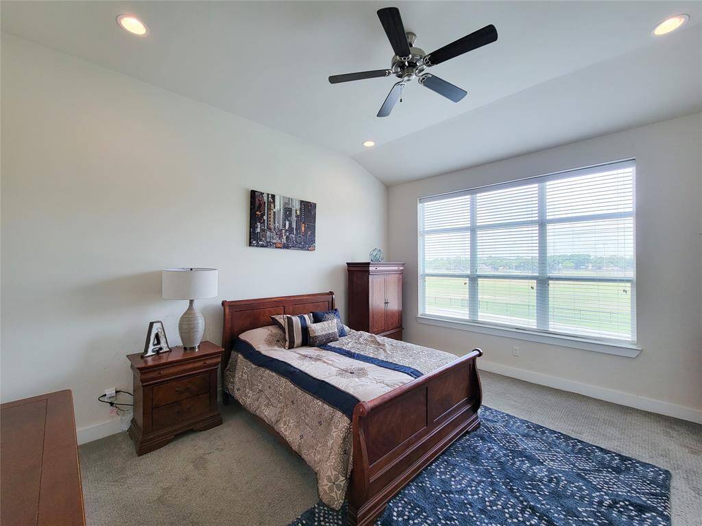 Large primary bedroom with a large window with a view of an open field.
