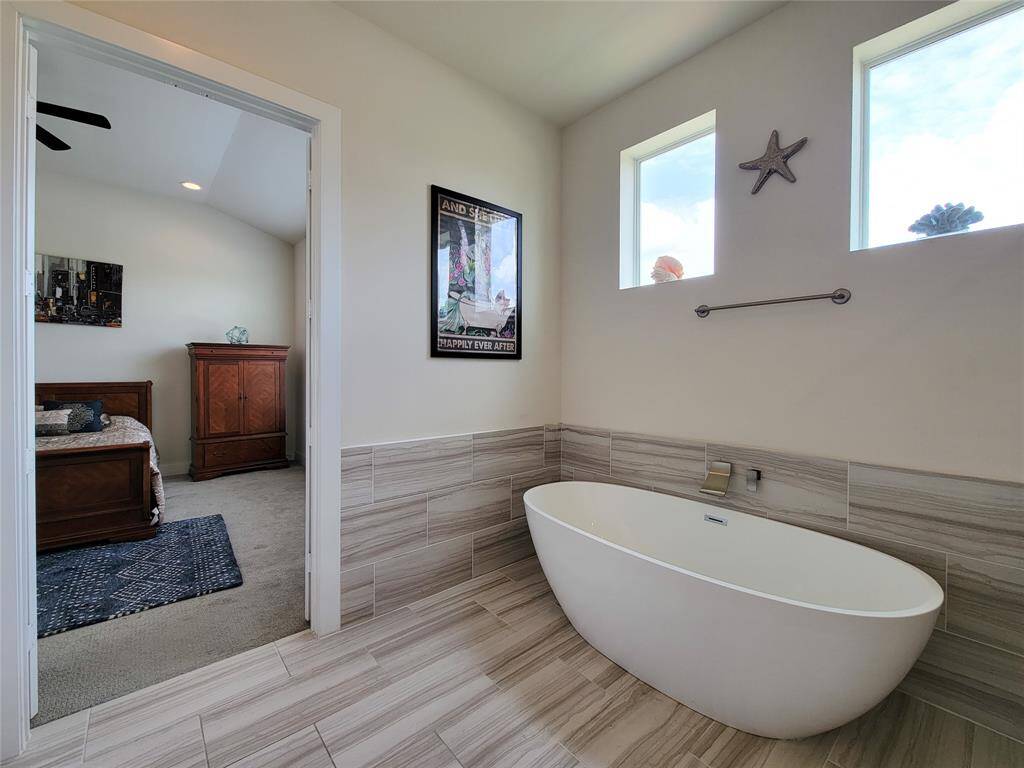 Modern bathroom with a freestanding tub, and tiled walls.