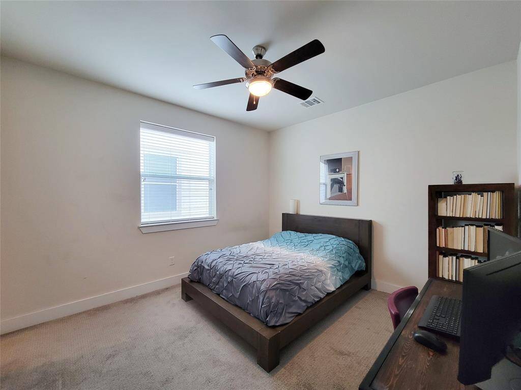 Middle bedroom with ceiling fan, and window with blinds.