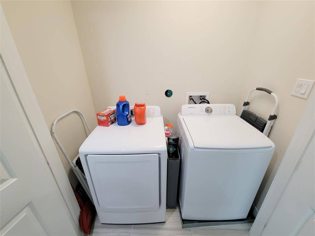 A laundry room with a white washer, dryer included.