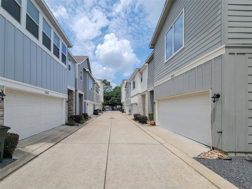 A residential alley with modern townhouses featuring prominent garages.
