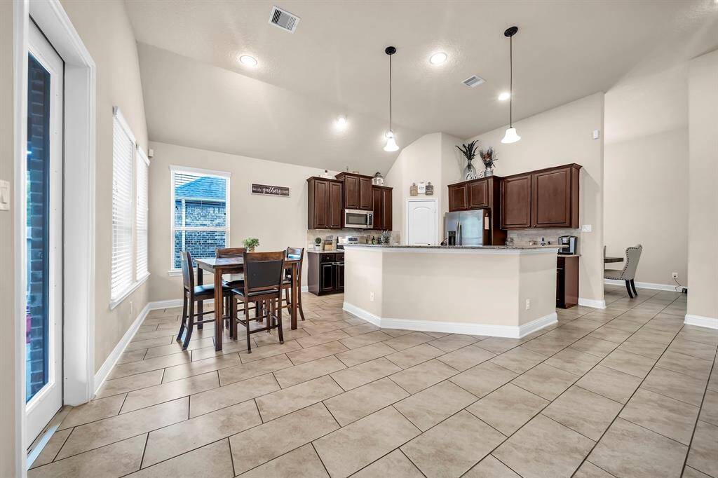 The spacious kitchen features stainless steel appliances, granite countertops, tile backsplash,abundant cabinet space,and a walk-in pantry.