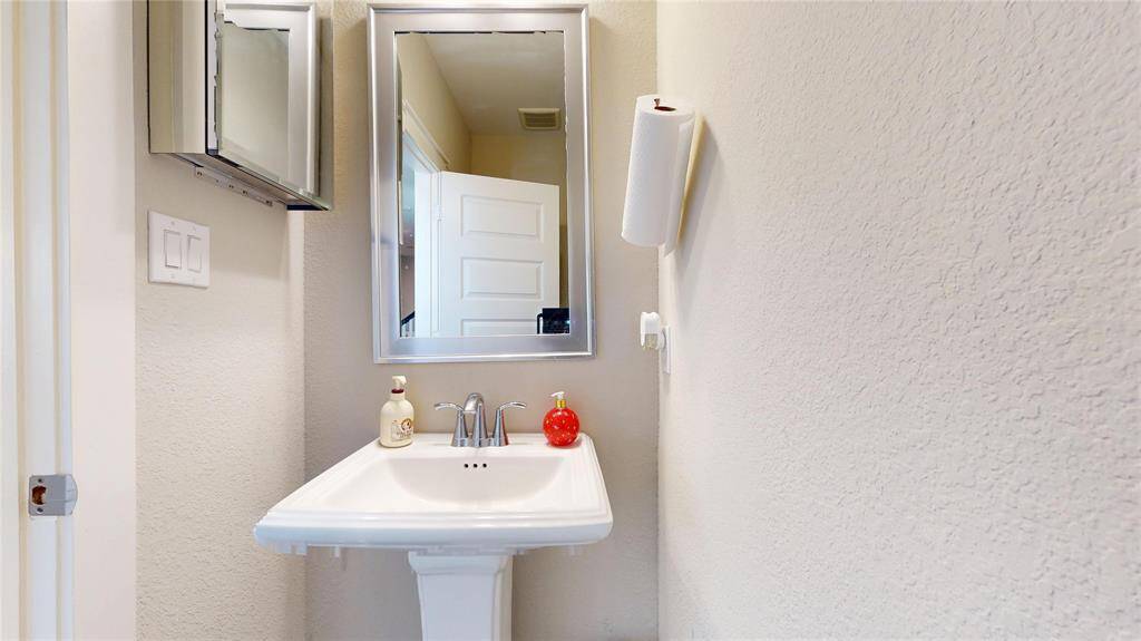 Elegant half bathroom featuring a classic pedestal sink.