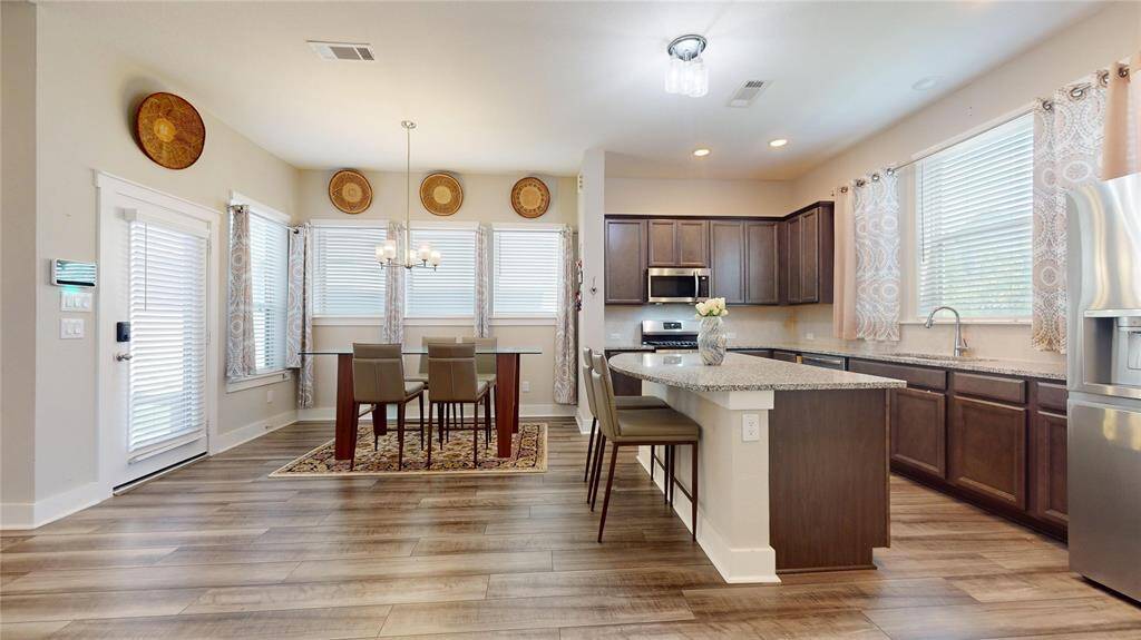 Modern kitchen with sleek appliances, spacious countertops, and an inviting dining area perfect for family meals and entertaining.