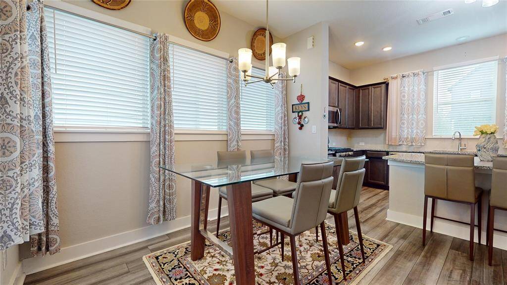 Modern dining area with elegant glass table, stylish seating, and abundant natural light. Perfect for intimate gatherings.