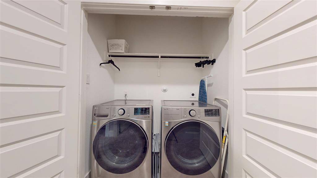 Efficient laundry room featuring modern appliances and ample shelving for organized storage.
