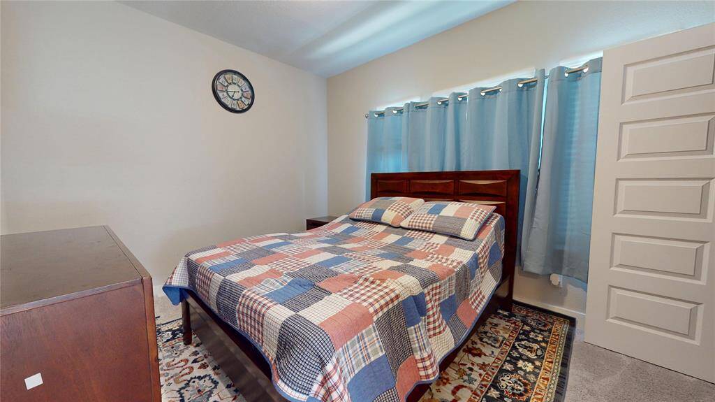 Inviting second bedroom with cozy carpet, ample natural light, and modern touches for a serene retreat.