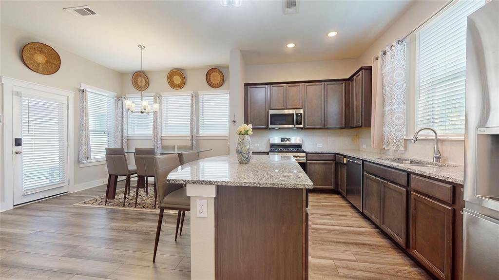 Bright kitchen and dining area with a central island and abundant natural light.