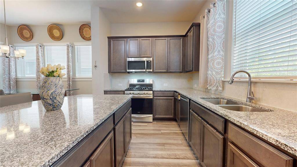 This stunning kitchen features sleek granite countertops, modern stainless steel appliances, and ample natural light, creating an inviting space perfect for cooking and entertaining.