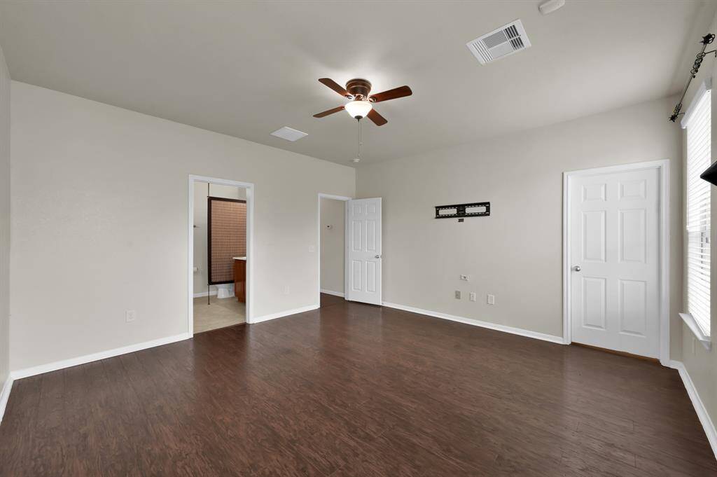 Master bathroom features a spacious double vanity with a large mirror, providing ample counter space. It has a modern, clean design with neutral tones, and includes a glass-enclosed shower.