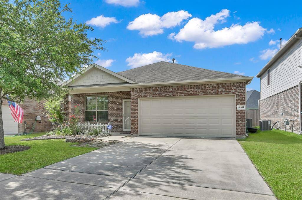Two-car garage and a welcoming front garden. Features a well-maintained lawn and a cozy front porch, perfect for relaxing.