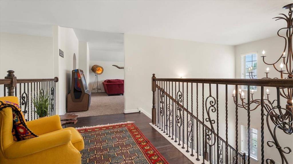 The second-floor landing offers a quiet sitting area, where warm hardwood flooring beautifully complements the soft, neutral wall tones—creating a peaceful and inviting retreat.