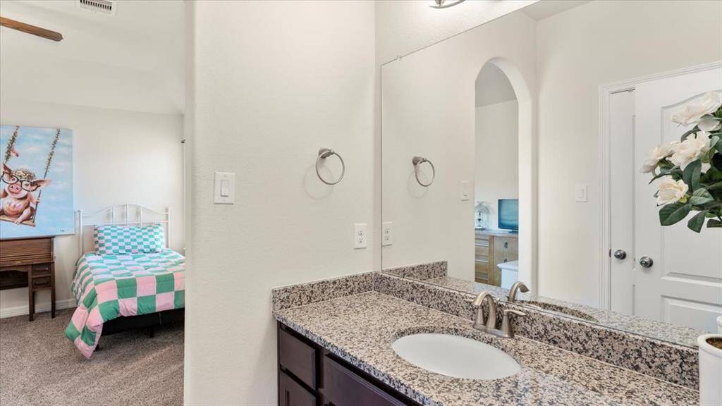 This side of the Jack-and-Jill bathroom features granite countertops and a single sink.