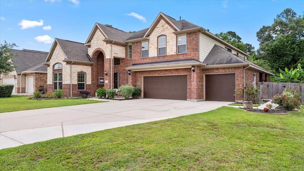 This two-story brick and stone residence boasts a three-car garage, a meticulously maintained front yard, and a spacious driveway. The home seamlessly blends classic charm with modern architectural details, creating an inviting curb appeal.