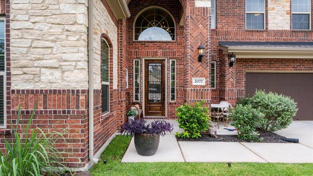 Charming brick exterior with a welcoming front entrance, featuring a decorative door and sidelights—creating an inviting space to greet your guests.