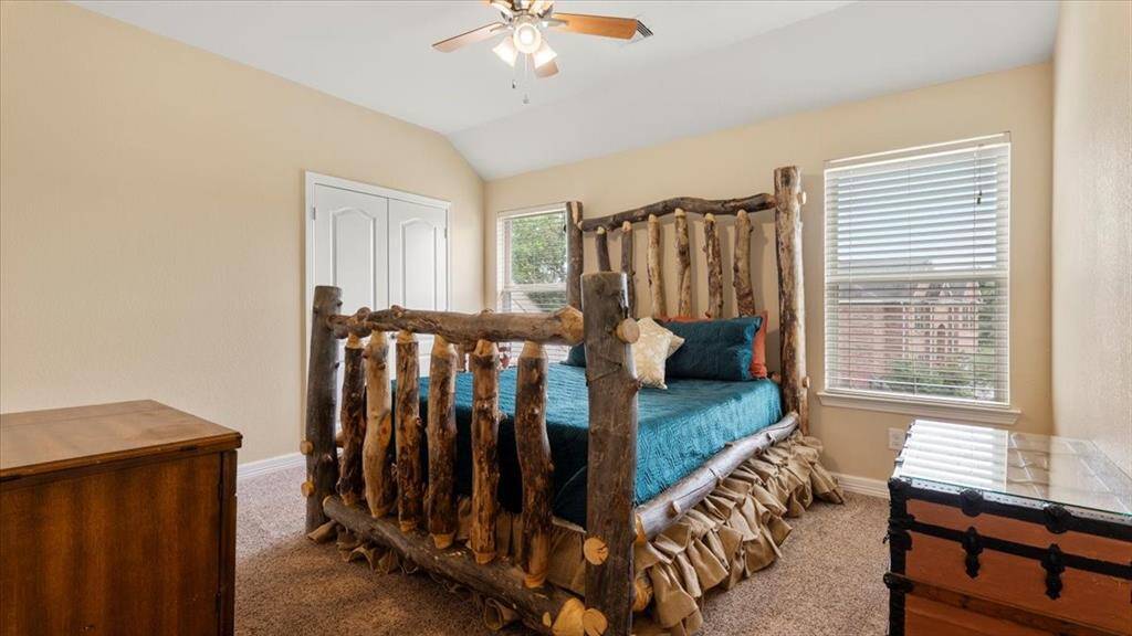 This bedroom offers high ceilings and abundant natural light streaming in through two large windows, creating a bright and airy atmosphere.
