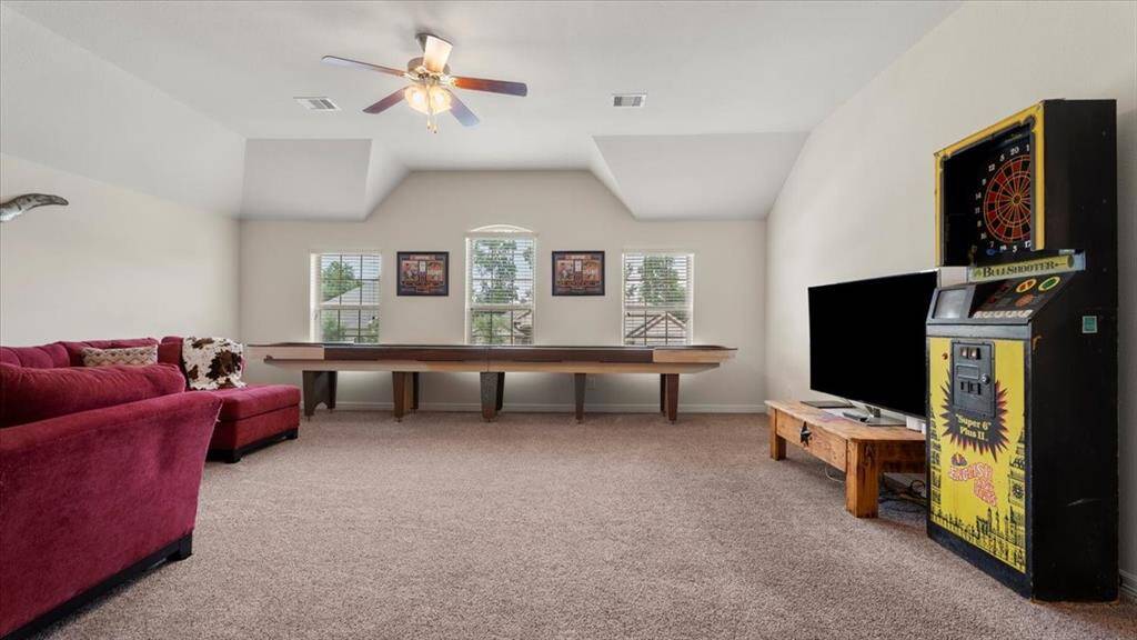 This spacious game room offers ample space for seating, a wall-mounted TV, game tables, and more—making it the perfect hangout spot for entertaining family and friends.