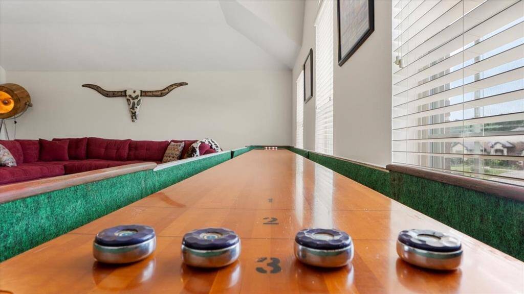 This spacious game room easily accommodates the shuffleboard table—which stays with the home—making it the perfect space for entertaining.