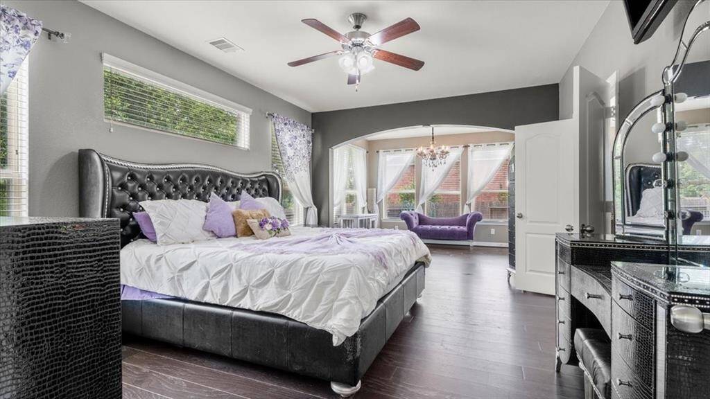 Spacious and elegant, the primary bedroom easily accommodates a grand bedroom set and is complemented by a modern ceiling fan and abundant natural light from large windows. It opens to a stylish sitting area with space for plush seating and features private access to the back patio—creating a luxurious retreat or an ideal nursery.