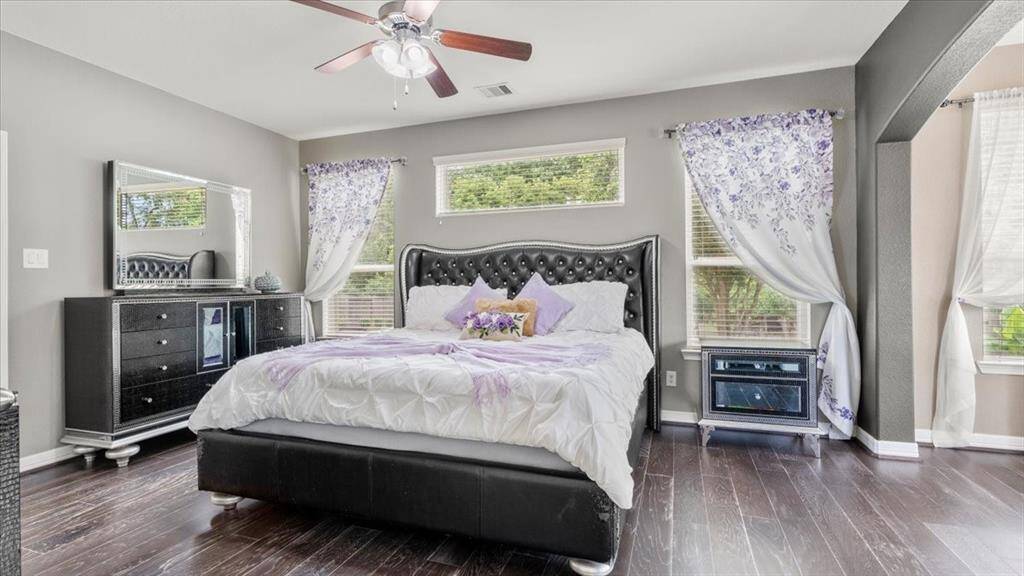 The spacious primary bedroom comfortably fits a grand bedroom set and large windows that fill the room with natural light—making it the perfect retreat after a busy day.