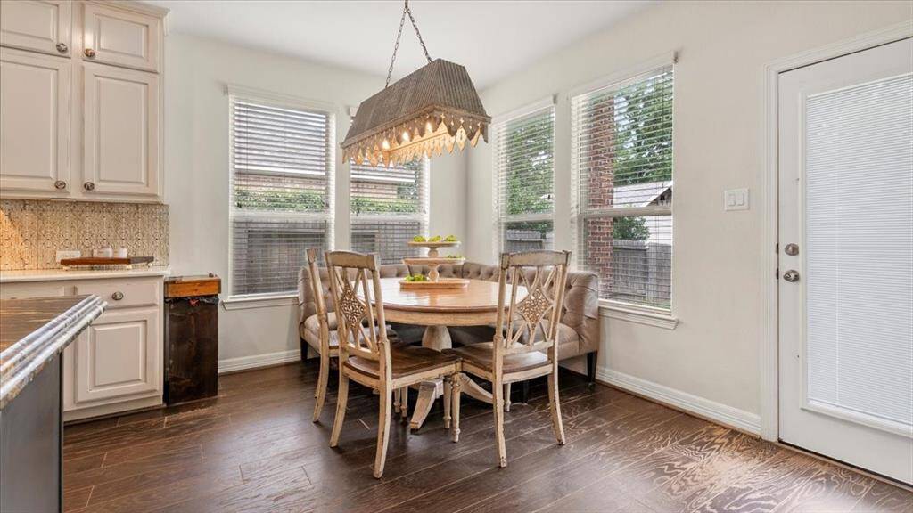 The breakfast area features large windows that flood the space with natural light, enhancing its warm and inviting atmosphere.