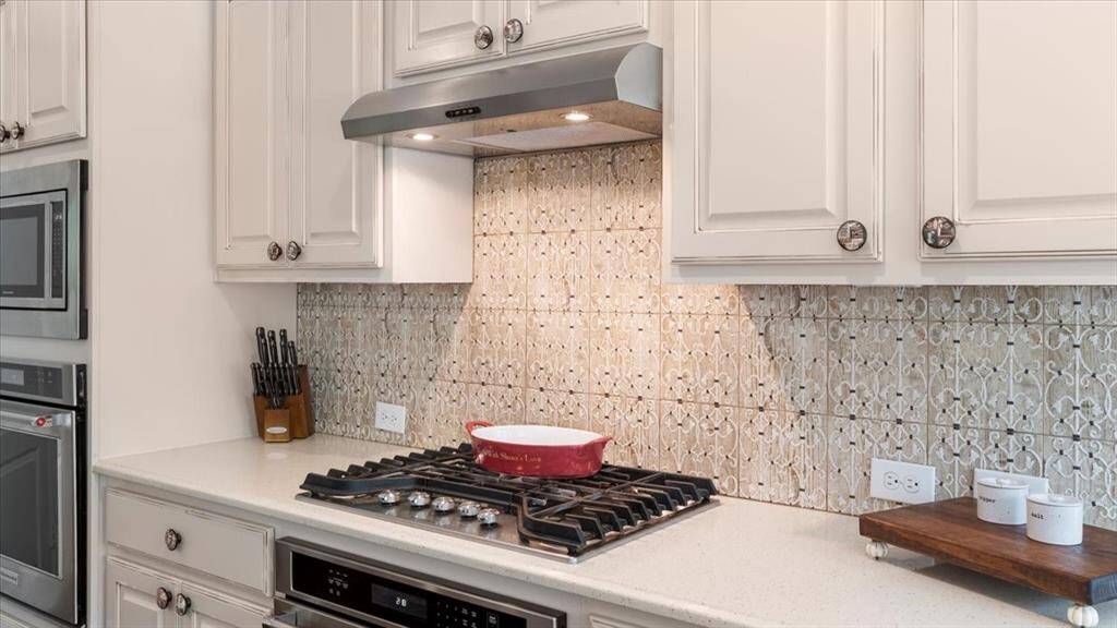The kitchen features a beautifully embossed tile backsplash, adding texture, charm, and visual interest to the space.