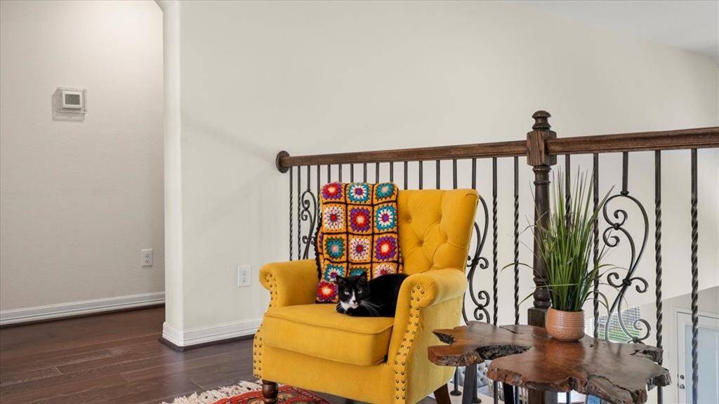 The second-floor landing offers a quiet sitting area, where warm hardwood flooring beautifully complements the soft, neutral wall tones—creating a peaceful and inviting retreat.