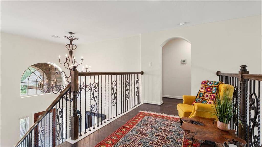 The second-floor landing offers a quiet sitting area, where warm hardwood flooring beautifully complements the soft, neutral wall tones—creating a peaceful and inviting retreat.