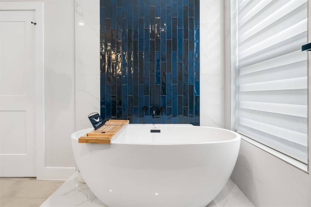 Stunning tiled wall behind the soaker tub in primary bathroom.