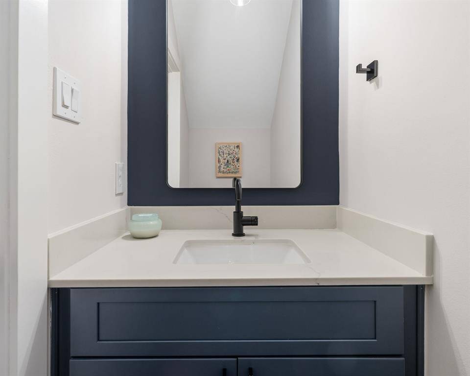 Guest bathroom is generously sized and has plenty of counter space.
